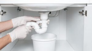 Siphon unter dem Waschbecken wird geöffnet